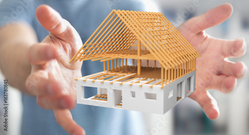 Tableau sur toile Businessman holding 3D rendering unfinished plan house in his hand
