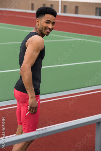 Handsome smiling african athlete man on running track © Drobot Dean