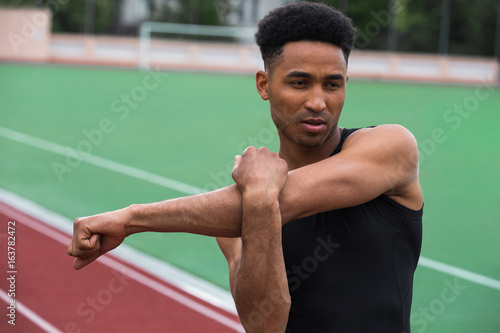 Handsome african athlete man make stretching exercises
