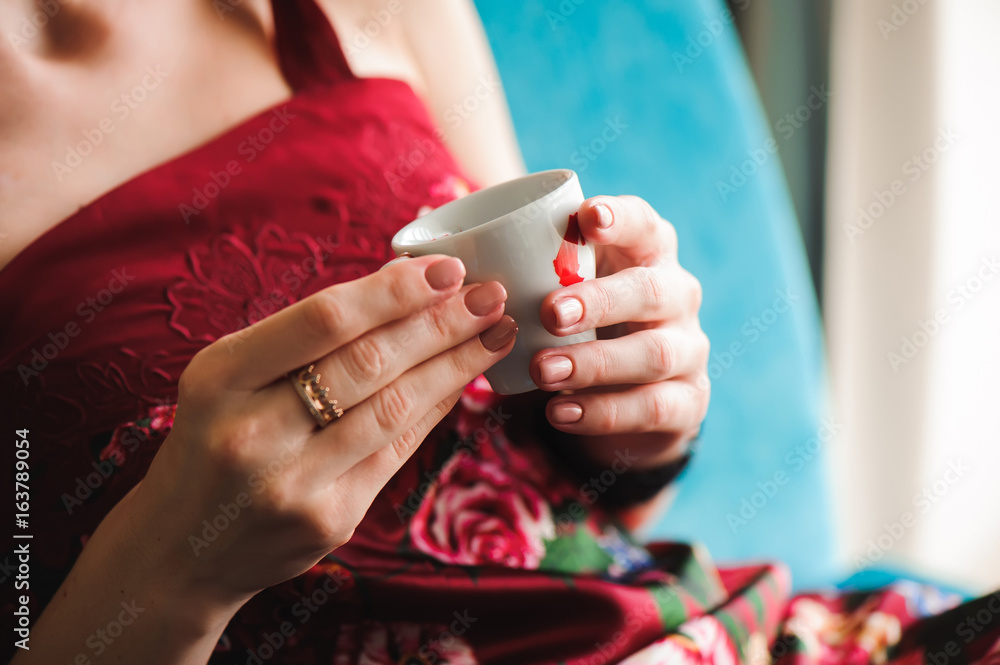 Close up of beautiful female hands holding white cup of coffee. Close up of beautiful female hands holding white cup of coffee.