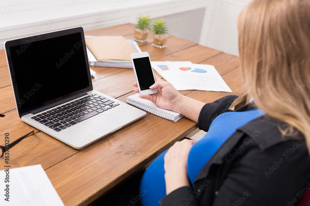 Pregnant woman working on phone with blank screen Pregnant woman working on phone with blank screen