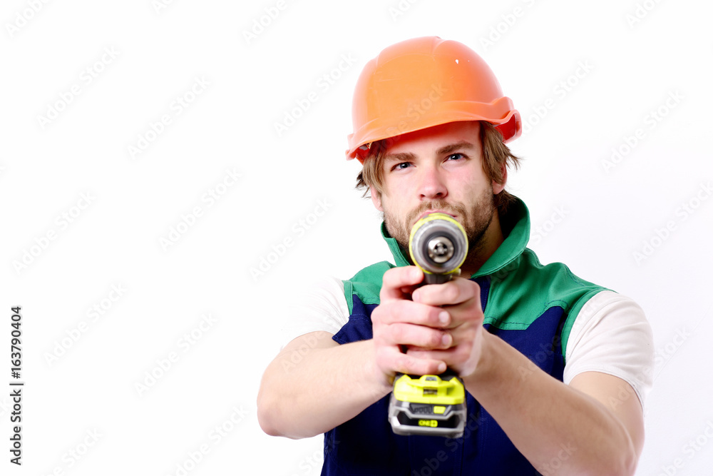 Construction worker holds yellow drill as gun. Builder with drill Construction worker holds yellow drill as gun. Builder with drill