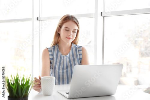 Smiling girl using laptop i...