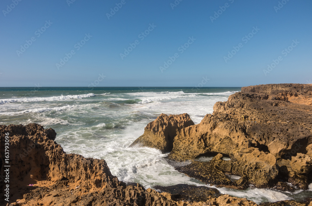 Waves  breaking of cliffs near Oualidia lagoon in same name village in Atlantic ocean coast, Morocco