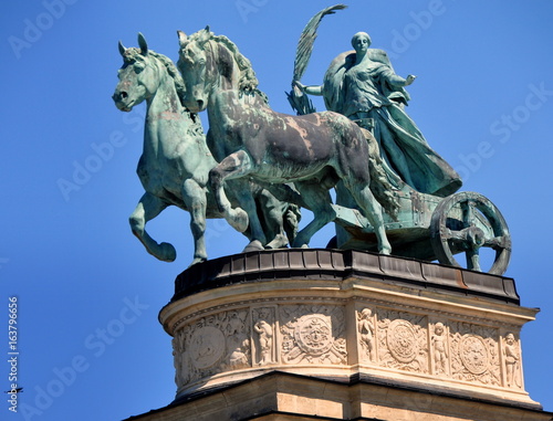 Statue des Friedens in einer Biga (Zwei-Pferde-Streitwagen) auf der Kolonnade des Heldenplatzes vor strahlend blauem Himmel