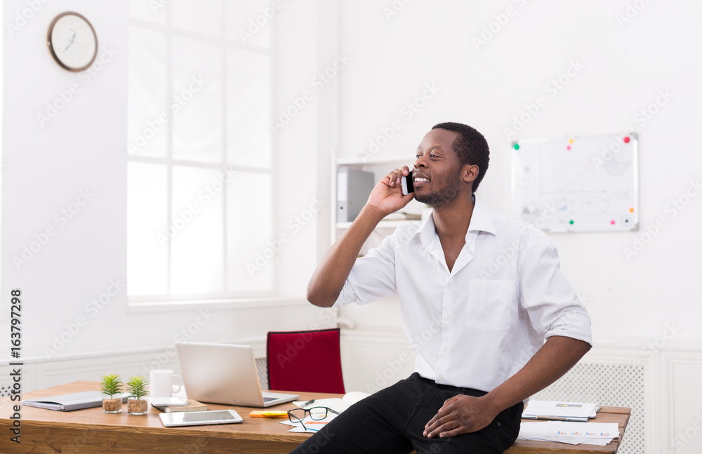 Young black businessman with mobile in modern white office Young black businessman with mobile in modern white office