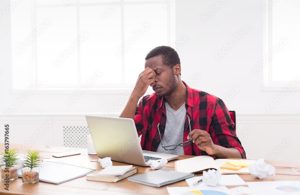 Tired black businessman in office, work with laptop Tired black businessman in office, work with laptop
