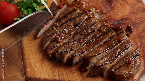 Beef steak on the board cut with a knife slow motion