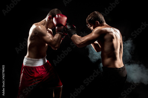 Two professional boxer boxing on black smoky background, © master1305
