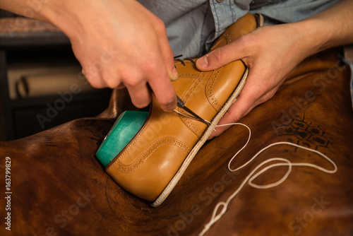 Shoemaker in workshop making shoes.