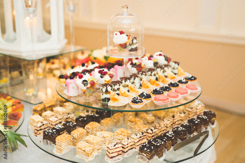 Delicious sweets on wedding candy buffet with desserts, cupcakes