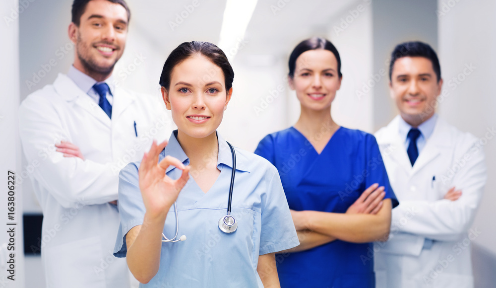 group of medics at hospital showing ok hand sign group of medics at hospital showing ok hand sign