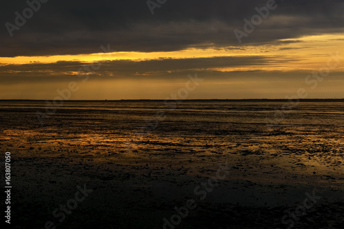 Reflections of sunset in low tide beach
