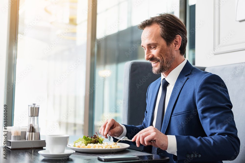 Joyful senior businessman enjoying meal in restaurant Joyful senior businessman enjoying meal in restaurant
