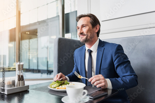 Happy businessman dreaming during dinner