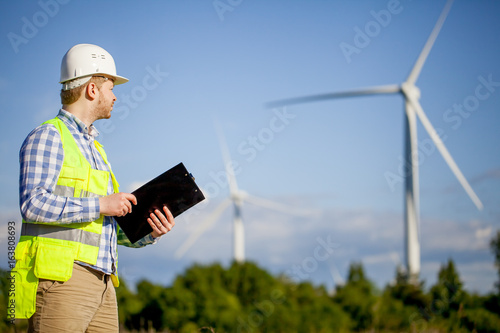 young engineer is checking on wind turbine energy production