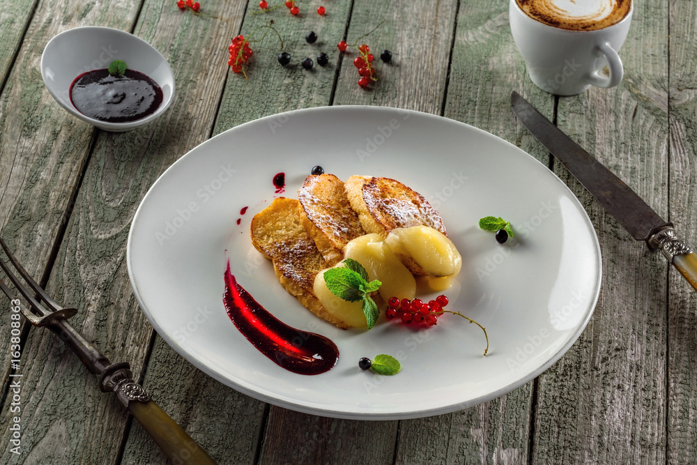 Delicious toasts with fruit jam and custard on a plate. Healthy European breakfast on a rustic wooden table.