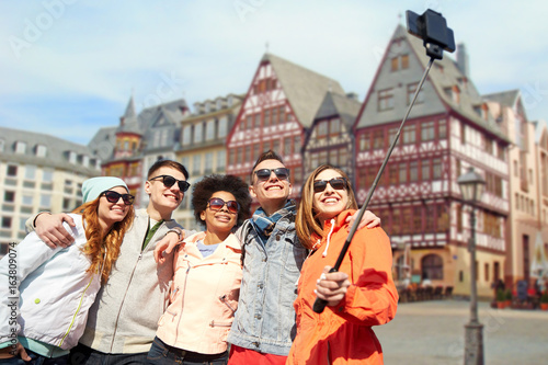 friends taking photo by selfie stick in frankfurt