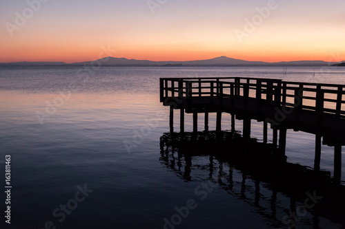 A pier on a lake at dusk  with beautiful soft and warm colors