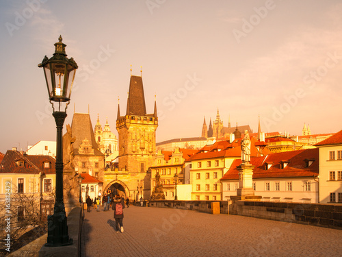 Charles Bridge with Lesser Town Bridge Tower and Prague Castle on background. Sunny morning in Prague, Czech Republic.