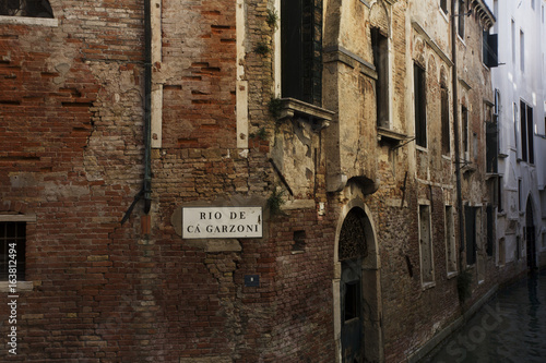 A taste of a typical Italian lifestyle in Venice, Ialy, Europe. Courtyards, laundry, green, balconies, brick and canals with boats in the summer.