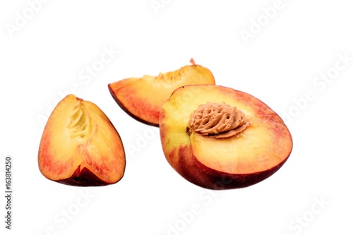 Peaches whole and sliced halves with a bone isolated on white background