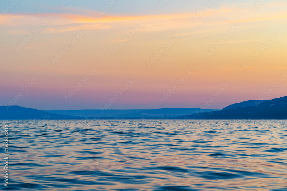 Summer seascape, scenery with blue water and colorful sunset sky background