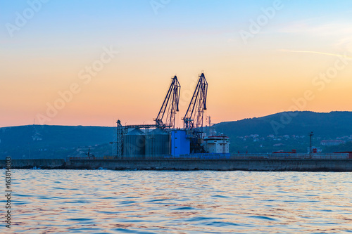 View of the sea port terminal with cranes at sunset time in Balchik, Bulgaria © O.Farion