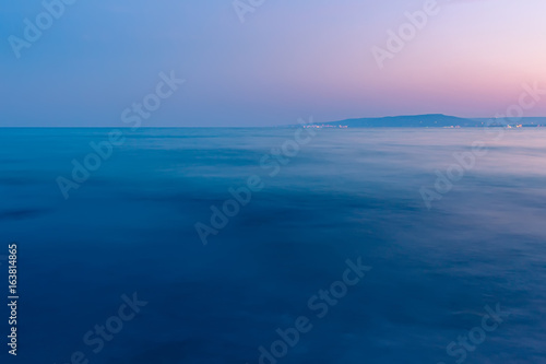 Summer seascape  scenery with blue water and colorful sunset sky background
