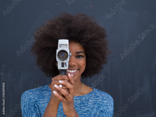 Φωτογραφία african american woman using a retro video camera
