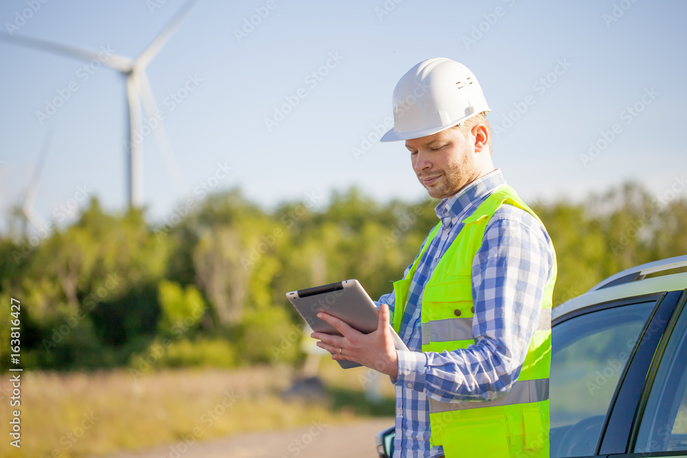 Fototapeta premium young engineer is checking on wind turbine energy production
