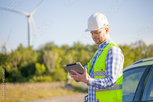young engineer is checking on wind turbine energy production