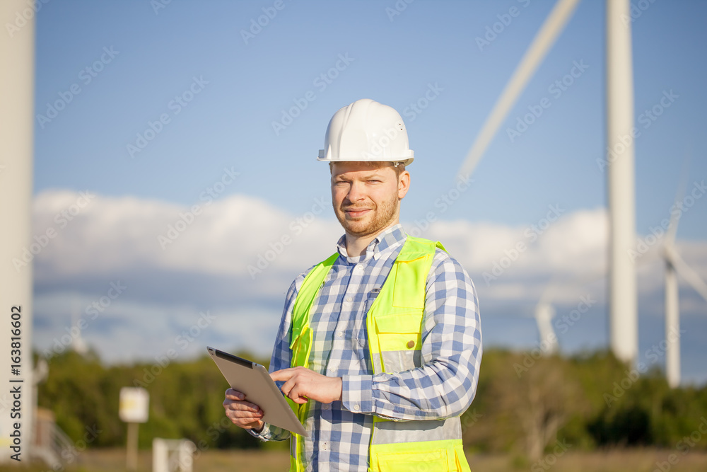 young engineer is checking on wind turbine energy production