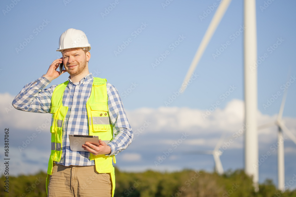 young engineer is checking on wind turbine energy production young engineer is checking on wind turbine energy production