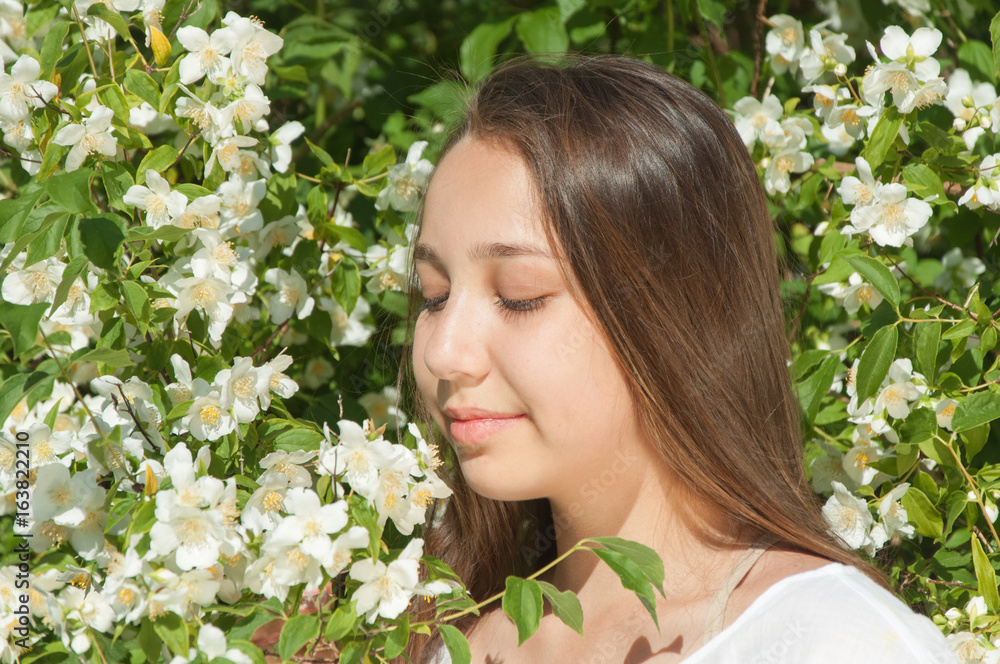 Girl near a bush of white flowers Girl near a bush of white flowers