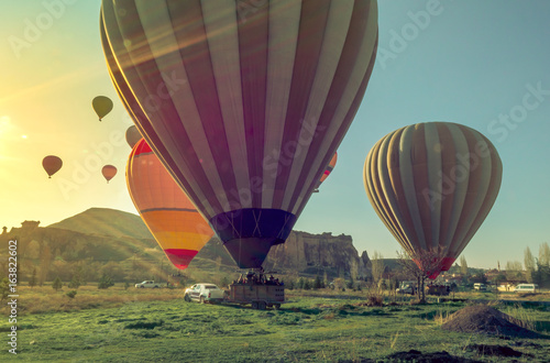 Hot air balloons landing at sunrise in sun beams after flying in the valley of Goreme.