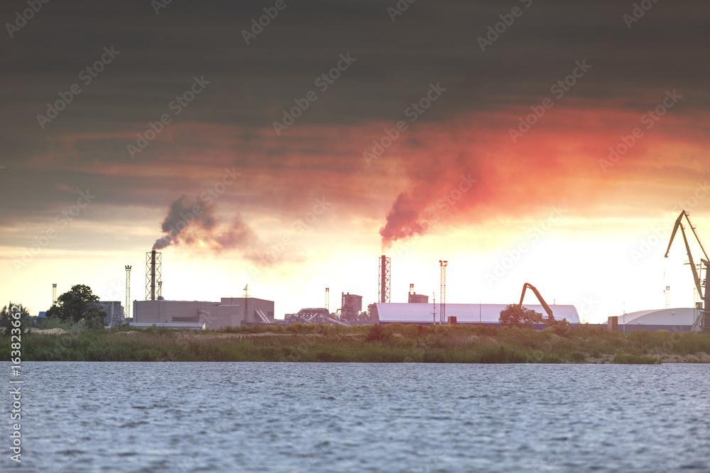 Air pollution by smoke coming out of two factory chimneys. Industrial zone in the city Air pollution by smoke coming out of two factory chimneys. Industrial zone in the city