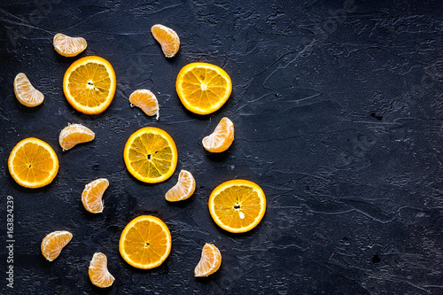 Citrus pattern. Orange and mandarin slices on black table background top view
