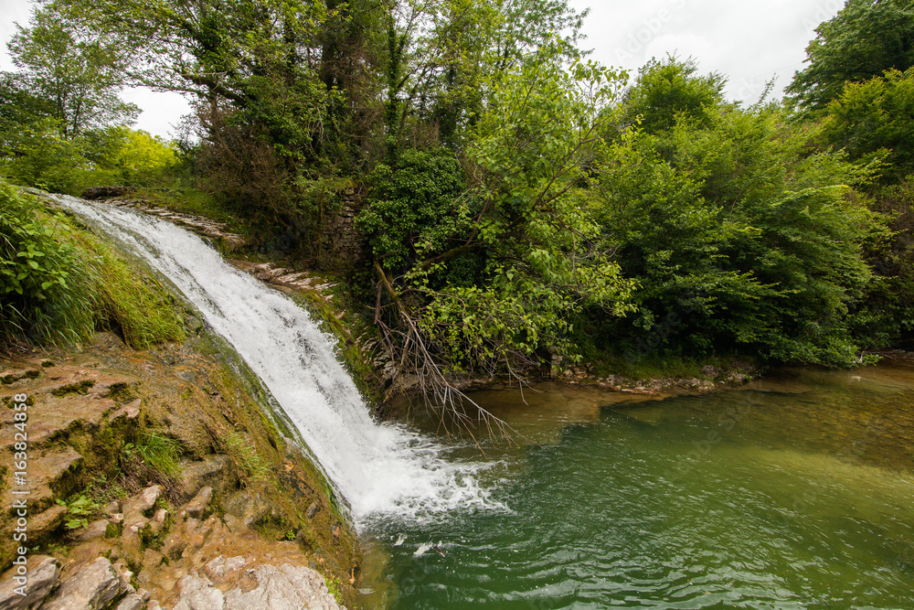 Fototapeta premium waterfall cascading down into a deep bowl