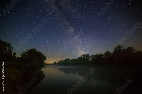Starry night sky with the Milky Way over the river.