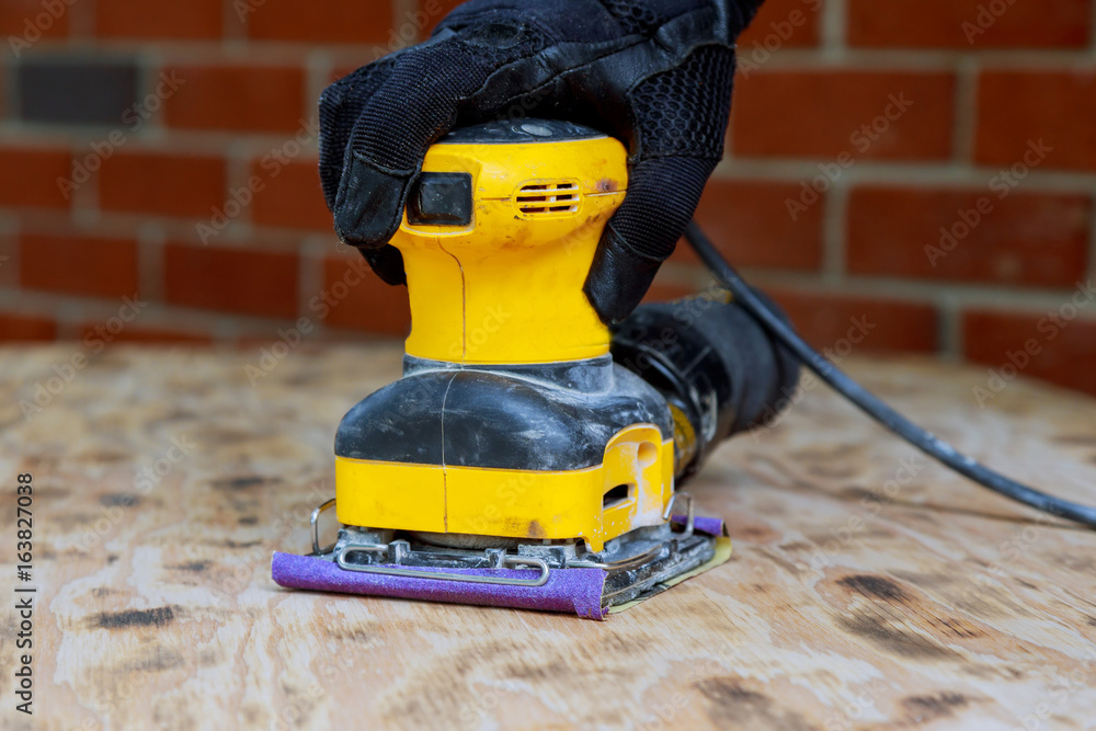 Home improvement handyman sanding wood in workshop Home improvement handyman sanding wood in workshop