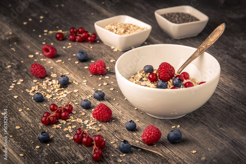 healthy breakfast with different berries and cereals on wooden background horizontal