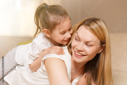 Mum and her cute daughter child girl are playing, smiling and hugging. Happy mother's day.