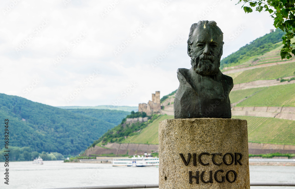 Obraz premium Büste von Viccor Hugo mit Burg Ehrenfels im Hintergrund