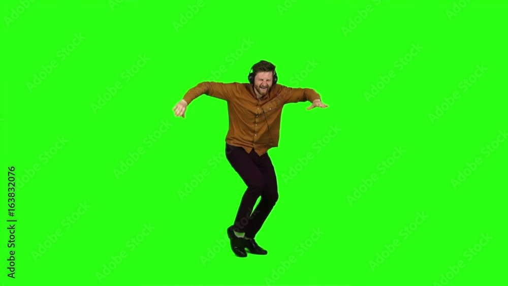 Businessman in headphones, whirl in dance. Green screen. Slow motion Businessman in headphones, whirl in dance. Green screen. Slow motion