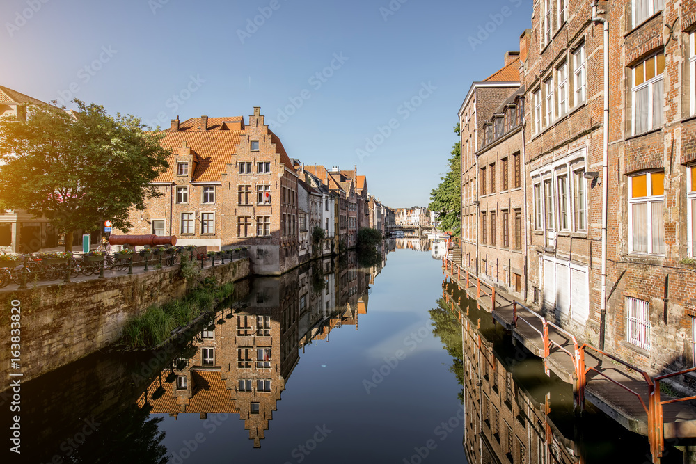 Riverside view with beautiful old buildings and water channel during the morning light in Gent city, Belgium