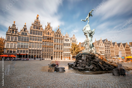 Wide angle view on the Grote Markt square with Brabo fountain in Atwerpen city, Belgium. Long exposure image technic with motion blurred people and clouds