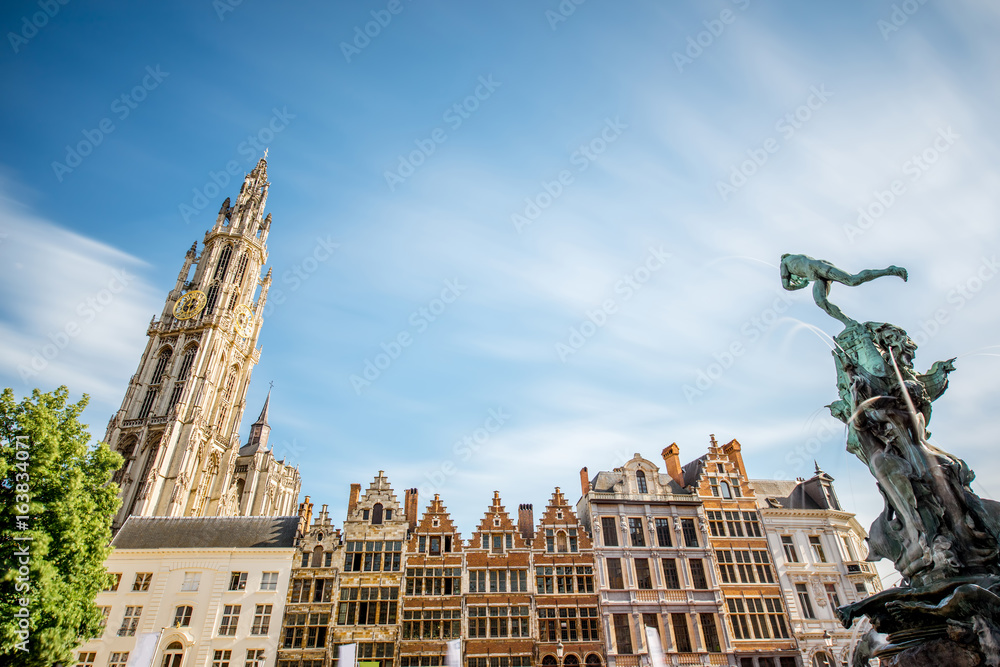 View on the beautiful buildings with fountain sculpture and church tower in the center of Antwerpen city in Belgium
