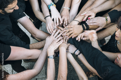 Different people putting hands in stack © karrastock