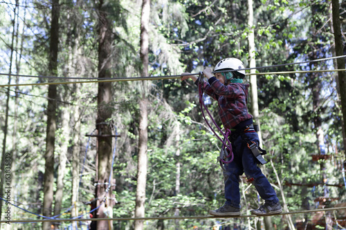 Boy climbing in adventure rope park